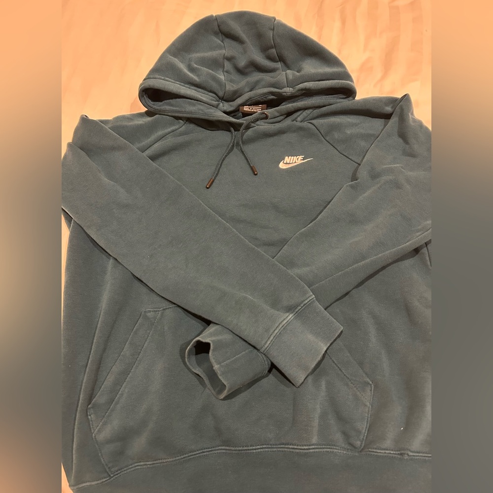 Blue/teal Nike sweatshirt tiny rip at the bottom right of the sweatshirt.